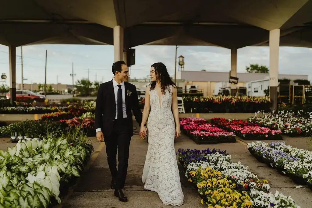 bride and groom walking through flowers at their eastern market wedding