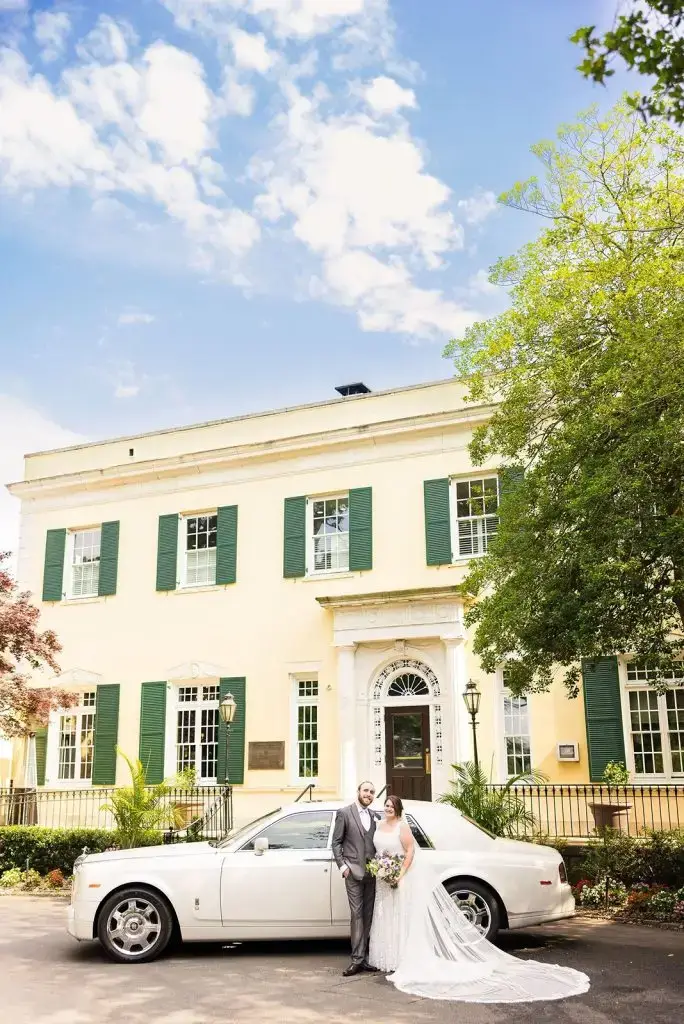 bride and groom outside their mansion at oyster bay wedding with a vintage car