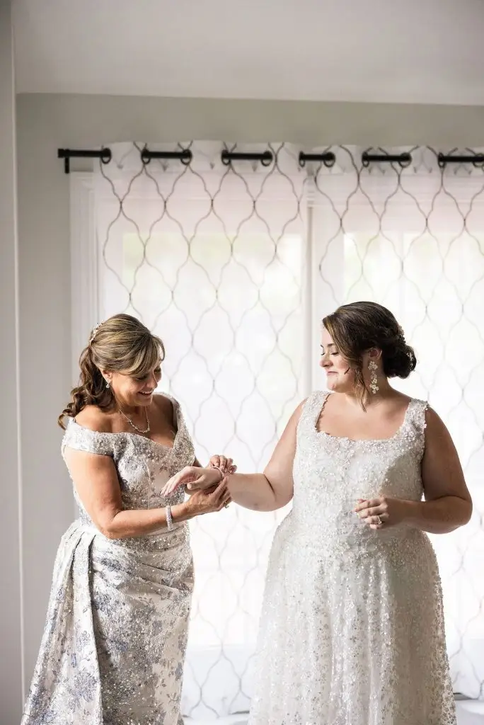 bride and her mom putting on jewelry