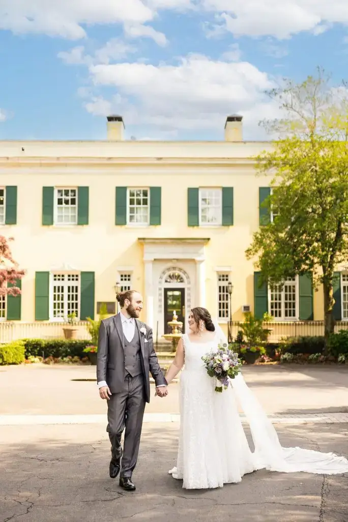 couple holding hands in front of Mansion at Oyster Bay - from Leah E. Moss Designs