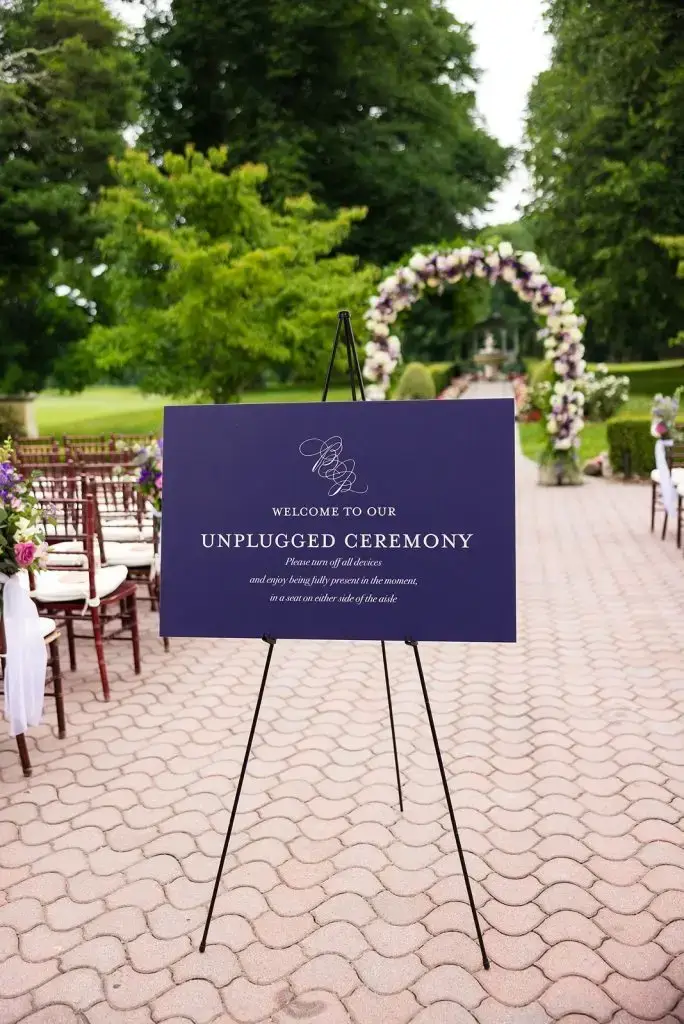 purple unplugged ceremony sign at an outdoor Mansion at Oyster Bay wedding ceremony - from Leah E. Moss Designs