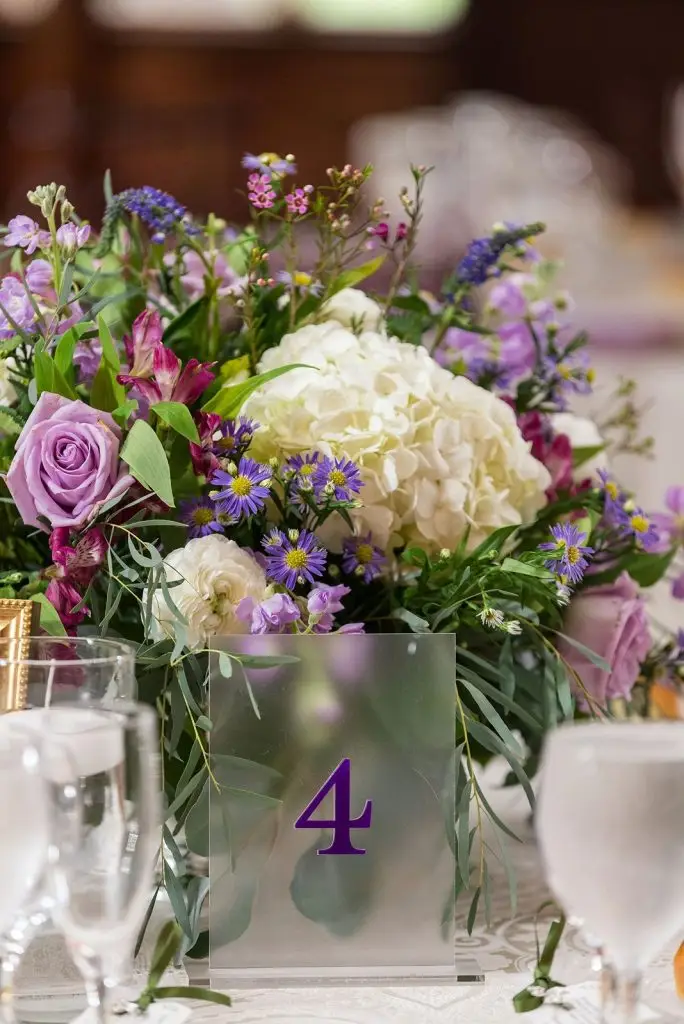 frosted clear and purple acrylic table number and purple floral centerpiece at a Mansion at Oyster Bay wedding - from Leah E. Moss Designs