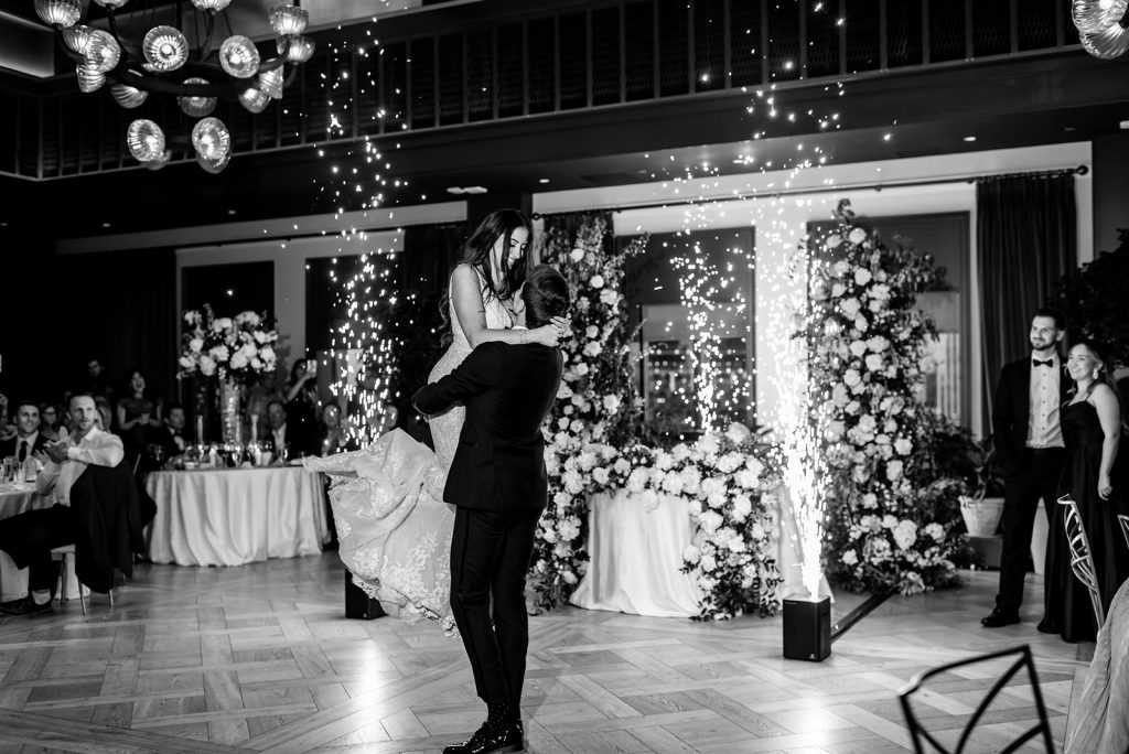 couple's first dance with sparklers at a book tower wedding