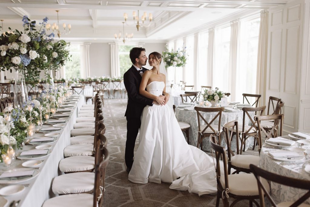 Bride and groom embrace in their Orchard Lake Country Club wedding reception space.